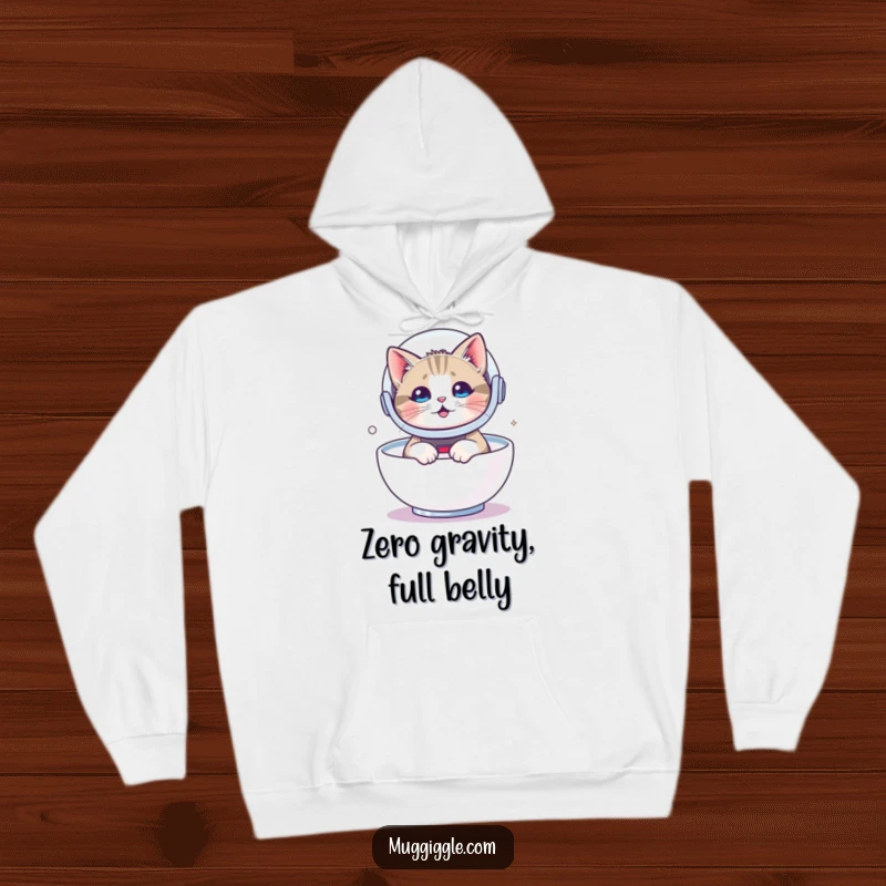 Funny hoodie depicting a cat in a tiny astronaut helmet, floating in milk, offering cozy comfort and galactic humor.