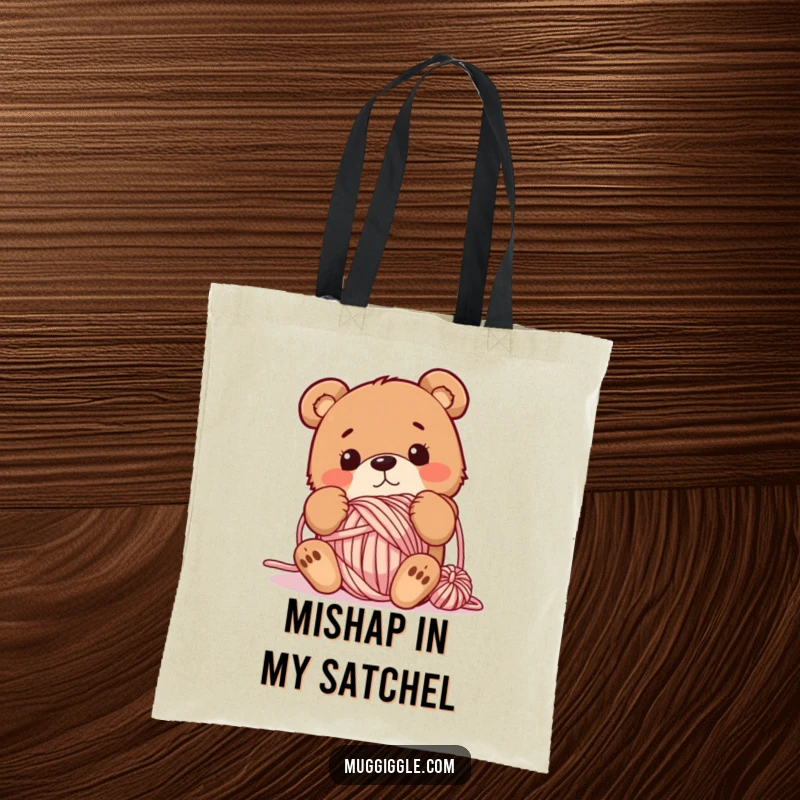 Funny tote bag featuring a bewildered bear tangled in a ball of yarn, ideal for carrying craft supplies or everyday items with humor.